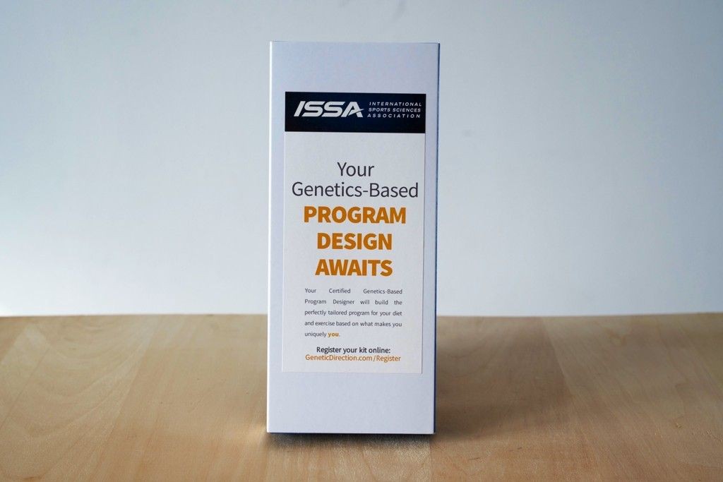 A promotional standee for ISSA's genetics-based program design, placed on a wooden surface.